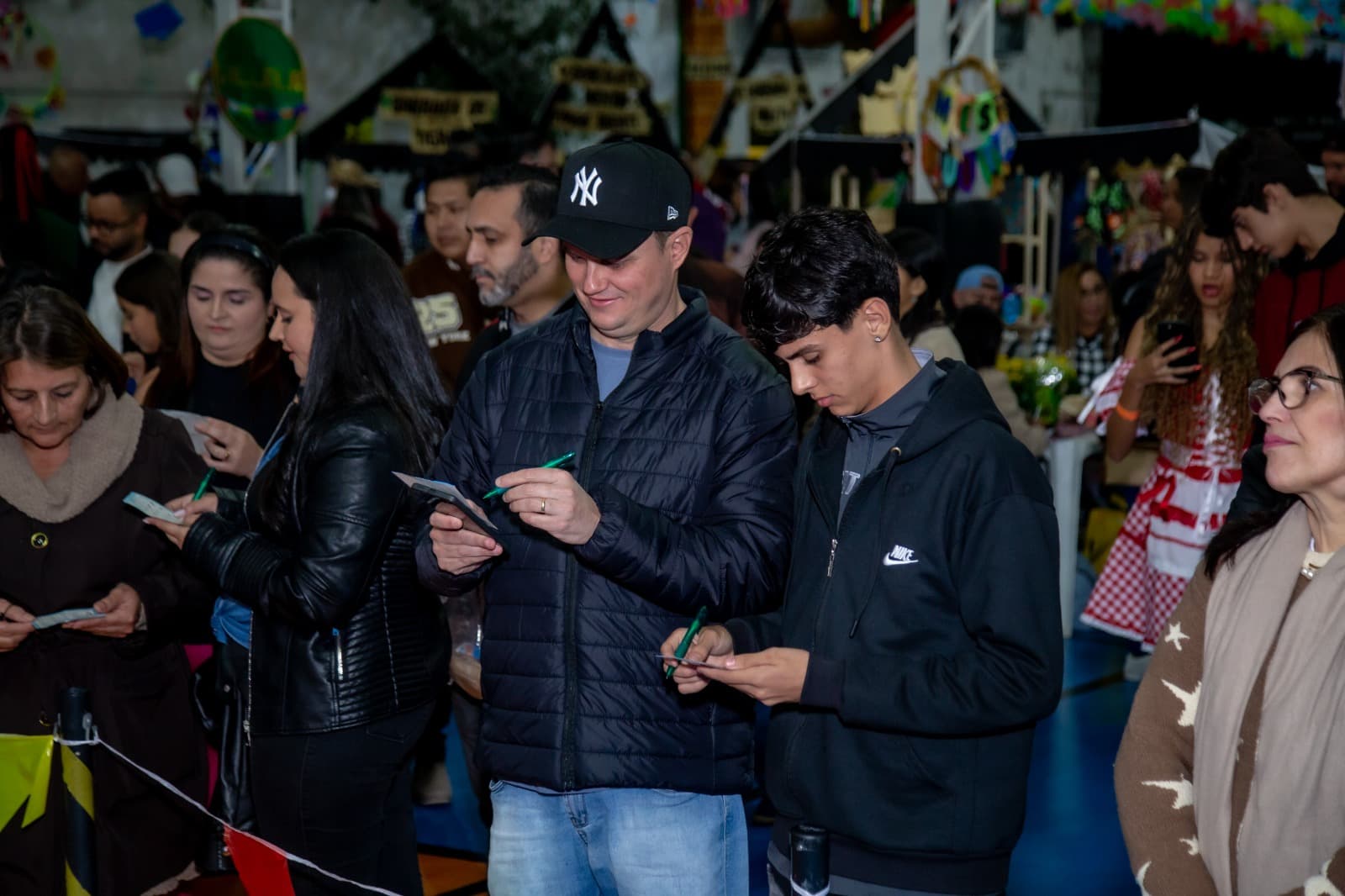 Famílias na entrada do Arraiá Scaranne preenchendo ingressos